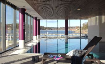 a large indoor pool surrounded by windows , with a view of the ocean in the background at Son Spa, an Ascend Member