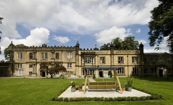 a large stone building with a courtyard and a swing set in front of it at The Old Lodge