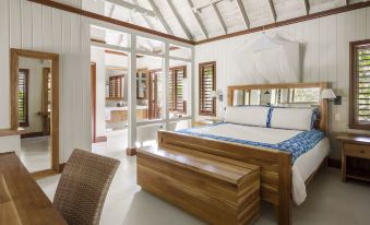 a large bed with a wooden headboard and footboard is in a room with white walls at GoldenEye