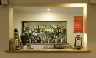 "a well - stocked bar with various bottles of alcohol , including some labeled "" cocktail "" and "" gin ,"" as well as a coffee" at Athelstane House