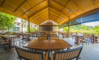 an outdoor dining area with wooden tables and chairs , as well as a stage set up for an event at Summer Bay Resort, Lang Tengah Island