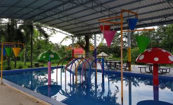 an outdoor pool with a water slide and a play area for children , surrounded by trees at Rainbow Resort