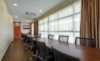 a large conference room with a long wooden table and several chairs arranged around it at Hamilton Hotel Kajang