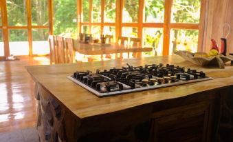 a dining room with a wooden table and chairs , along with a gas stove on the counter at Volcano House