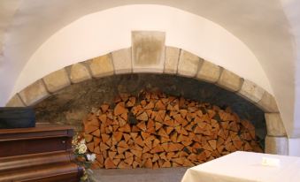 a room with a large pile of firewood on the floor and a wooden bench next to it at Leslie Castle