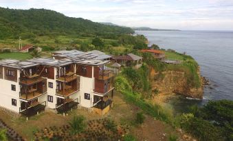 a group of houses situated on a cliff overlooking a body of water , possibly a lake at The Sea Cliff Hotel Resort & Spa