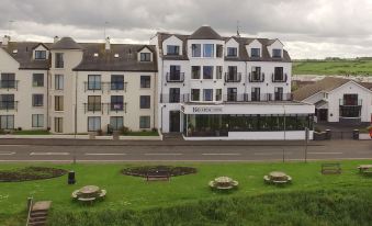 "a large white building with a sign that says "" charmington hotel "" is surrounded by grass and greenery" at Bayview Hotel