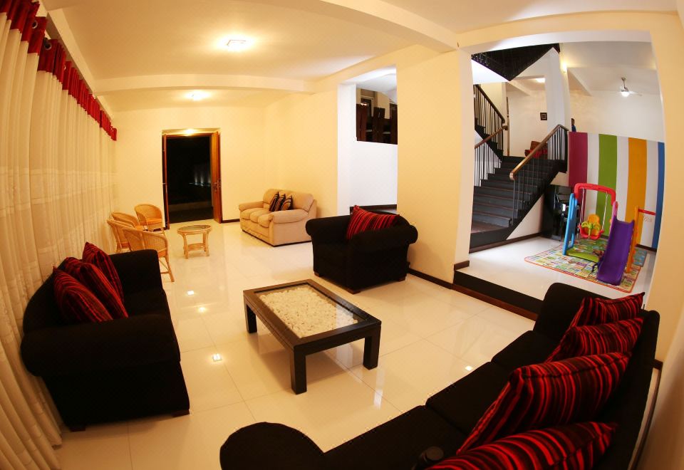 a spacious living room with multiple couches and chairs , creating a comfortable and inviting atmosphere at Capital Villa