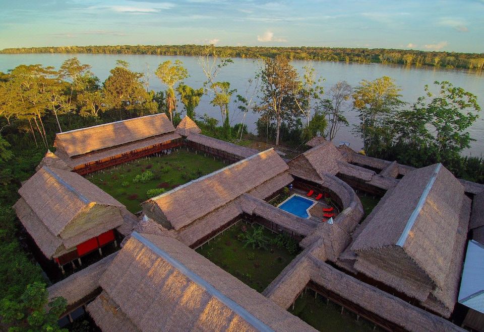 aerial view of a resort on the banks of a river , surrounded by lush greenery at Heliconia Amazon River Lodge