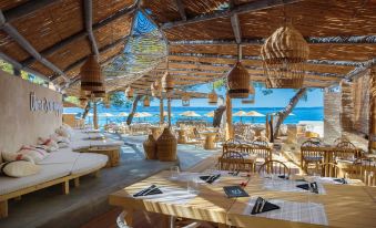 an outdoor dining area at a beachside restaurant , with tables and chairs arranged for guests to enjoy the view of the ocean at Le Méridien Lav, Split