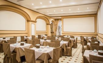 a large , empty conference room with multiple tables and chairs set up for meetings or events at Hotel Europa