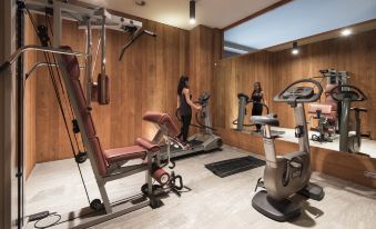 a well - equipped gym with various exercise equipment , including treadmills , stationary bikes , and weight machines at Grand Hotel Della Posta