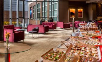 a large dining room with multiple tables and chairs , some of which are occupied by people at Radisson Blu Hotel, Szczecin