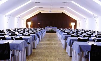 a large , well - lit conference room with rows of tables and chairs arranged in an orderly fashion at Parador de La Granja