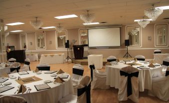 a well - decorated banquet hall with tables covered in white tablecloths and chairs arranged for a formal event at Causeway Bay Hotel