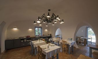 a large dining room with multiple tables and chairs , as well as a chandelier hanging above at Herdade Do Touril