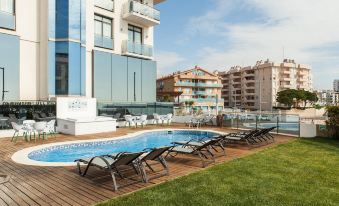 a hotel with a large outdoor pool surrounded by lounge chairs , providing a relaxing atmosphere at Hotel Flamingo