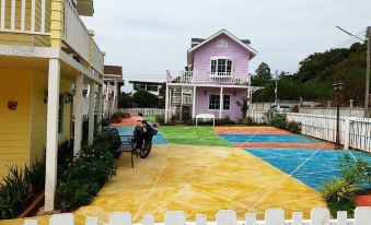 a colorful house with a basketball court in the front yard , surrounded by a fence at Bunny Hill Resort
