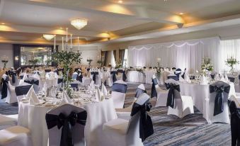 a large banquet hall with multiple tables and chairs set up for a formal event , possibly a wedding reception at Actons Hotel Kinsale