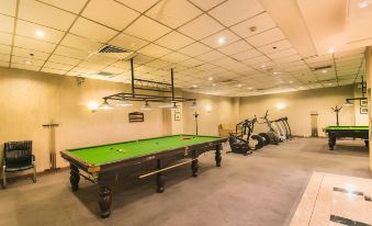 a large room with a green pool table and exercise equipment , including treadmills and bikes at Lanzhou Feitian Hotel (Lanzhou University Subway Station)