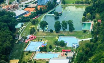 an aerial view of a large , well - maintained park with multiple swimming pools and tennis courts at Hotel Dixon so Vstupom do bazéna a vírivky Zdarma - Free Entrance to Pool and Jacuzzi Included