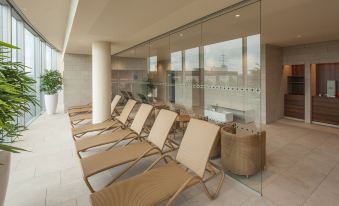 a row of lounge chairs is lined up against a glass wall in an indoor setting at Four Points by Sheraton Panoramahaus Dornbirn