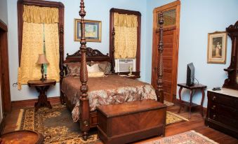 a bedroom with a wooden bed , dresser , and other furniture , including a tv on the dresser at Blythewood Plantation