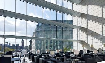 a large , modern building with an atrium that is filled with comfortable seating and offers a view of the city at Park Plaza Westminster Bridge London