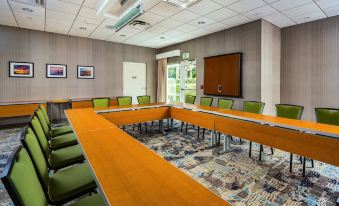 a conference room with a large table and several chairs arranged in a semicircle around it at SpringHill Suites Vero Beach