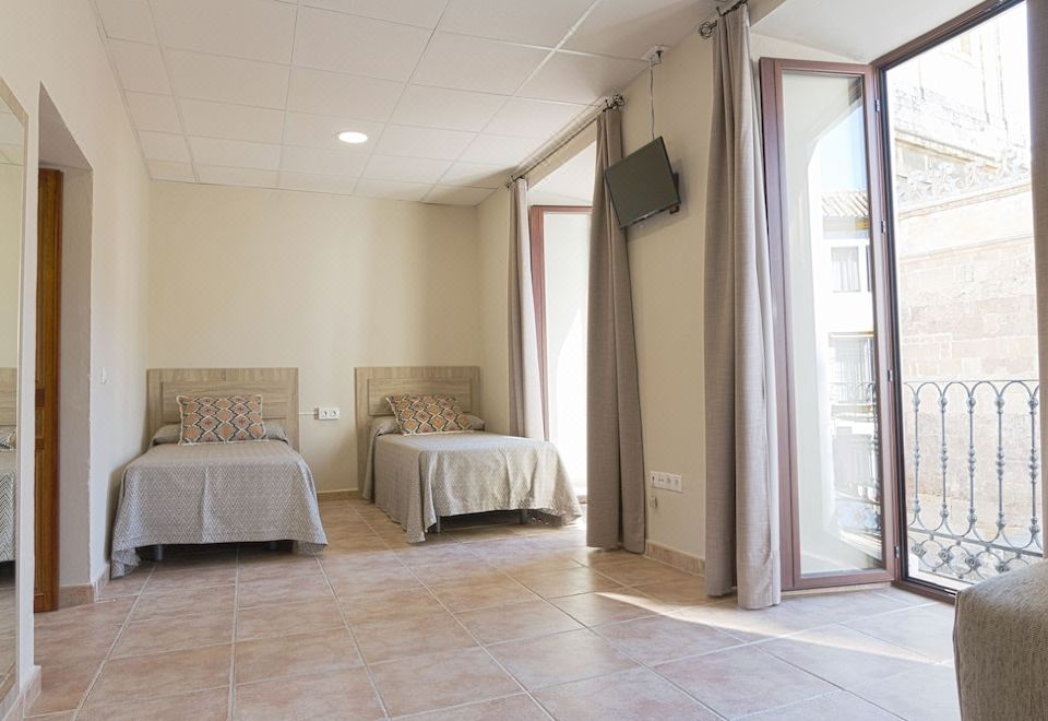 a hotel room with two beds , one on the left and one on the right side of the room at La Torre