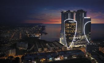 a cityscape at night with tall buildings and a body of water in the background at DoubleTree by Hilton Melaka