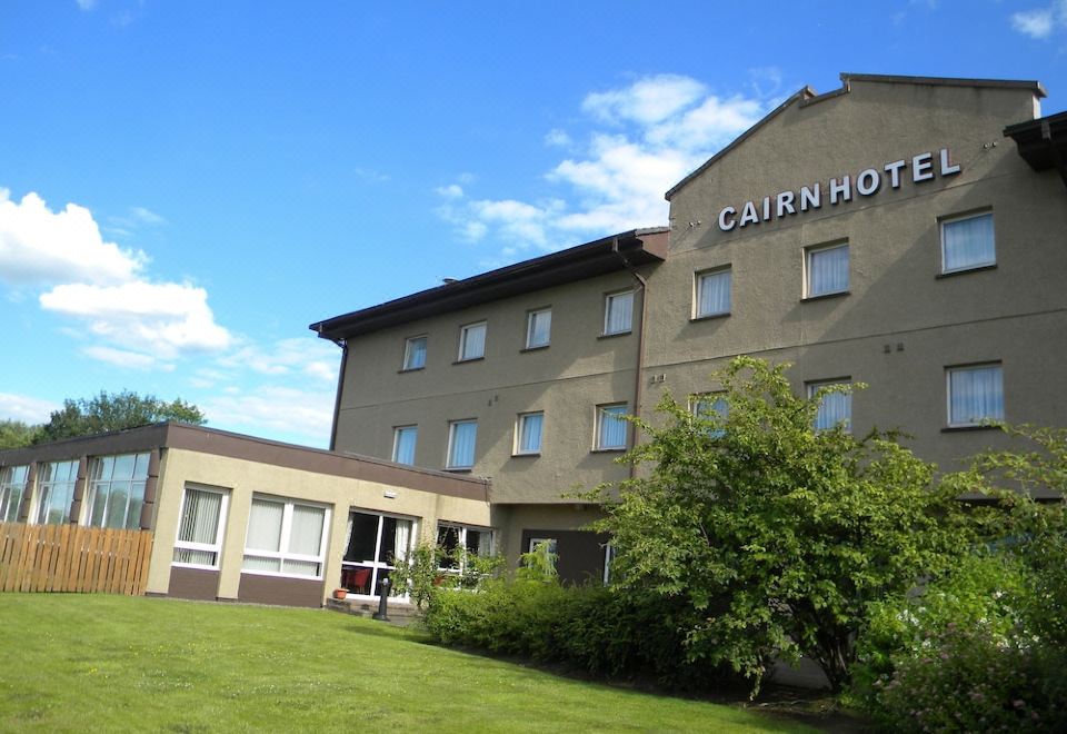 "a large hotel building with a sign that reads "" cairn hotel "" prominently displayed on the front of the building" at Cairn Hotel