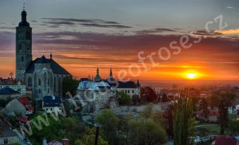 a beautiful sunset over a city , with the sun setting behind a castle - like structure and trees at House of Roses