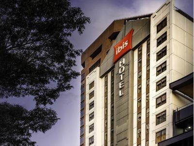 "a large hotel with a red sign that says "" ibis hotel "" on the side of the building" at Ibis Melbourne Hotel and Apartments
