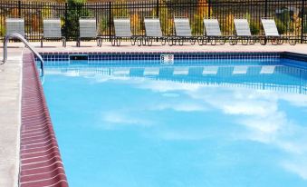 a swimming pool surrounded by lounge chairs and a fence , with a view of the surrounding landscape at The Inn at Silvercreek
