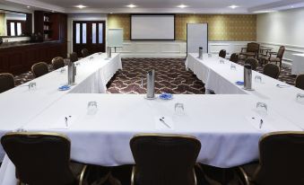 a conference room set up for a meeting , with several chairs arranged in a semicircle around a long table at Peppers the Hills Lodge