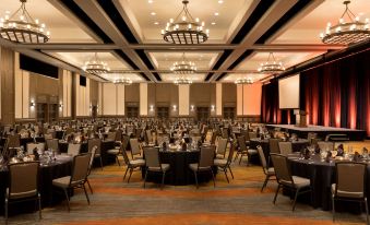 a large conference room with multiple round tables and chairs , set up for an event at Hyatt Regency Tamaya Resort and Spa