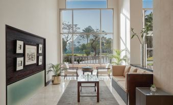 a spacious living room with a large window , allowing natural light to fill the space at Marriott Mena House, Cairo