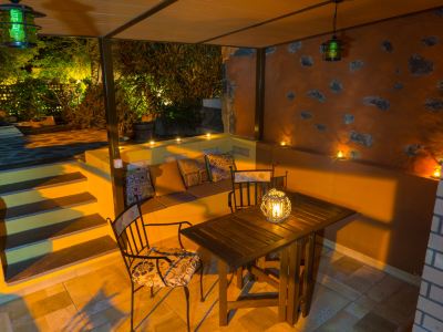 an outdoor dining area with a table , chairs , and a chandelier , surrounded by a patio with a pool at Titi Titi Photo