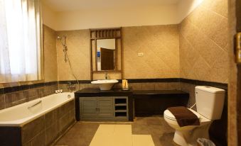 a modern bathroom with beige walls , a gray bathtub , and a toilet , along with a sink , mirror , and towel rack at Sunny Villa