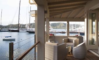 a wooden deck overlooking a body of water , with several boats visible in the distance at South Point Antigua