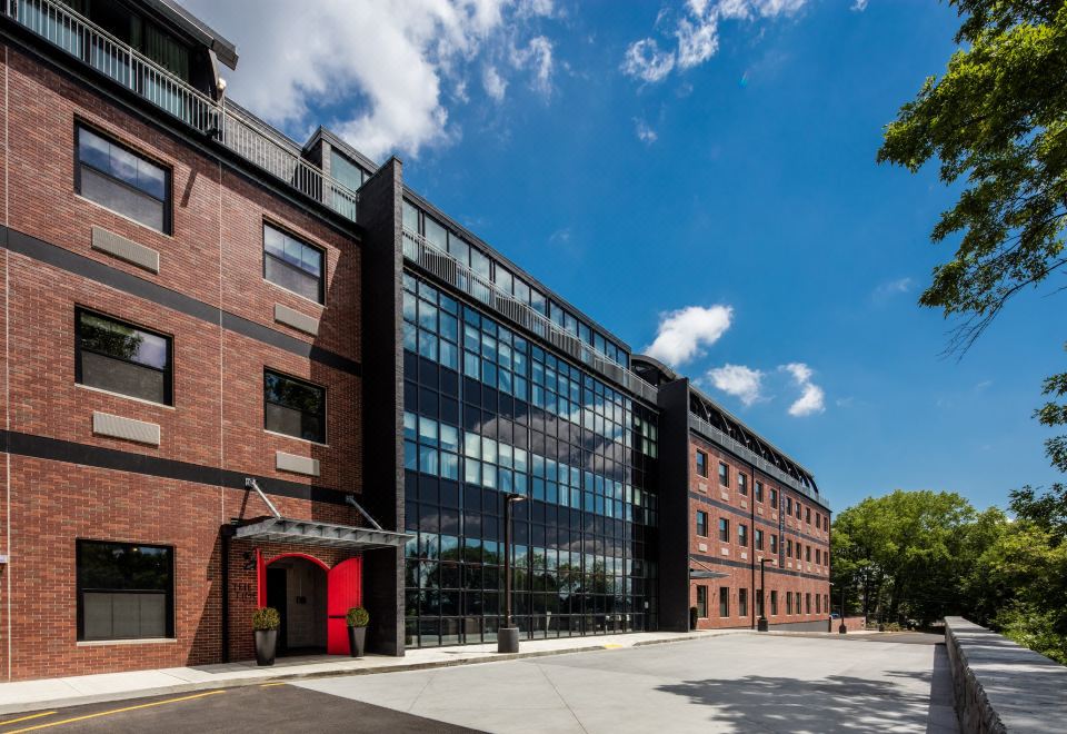 a modern building with a red door and windows , surrounded by trees and under a blue sky at Hotel Nyack, A Joie de Vivre Hotel by Hyatt