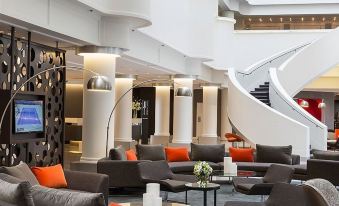 a modern hotel lobby with multiple couches and chairs arranged in a seating area , creating a comfortable and inviting atmosphere at Pullman Melbourne Albert Park