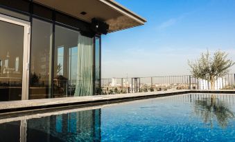 a modern swimming pool and surrounding area , including a clear blue swimming pool , surrounded by white walls and windows at Hotel Viu Milan
