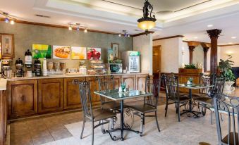 a modern cafe with wooden cabinets , marble floors , and large windows , featuring a dining area with tables and chairs at Quality Inn South Hill I-85