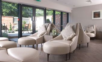 a room with three beige chairs arranged in a circle , possibly in a waiting area at Macdonald Craxton Wood Hotel