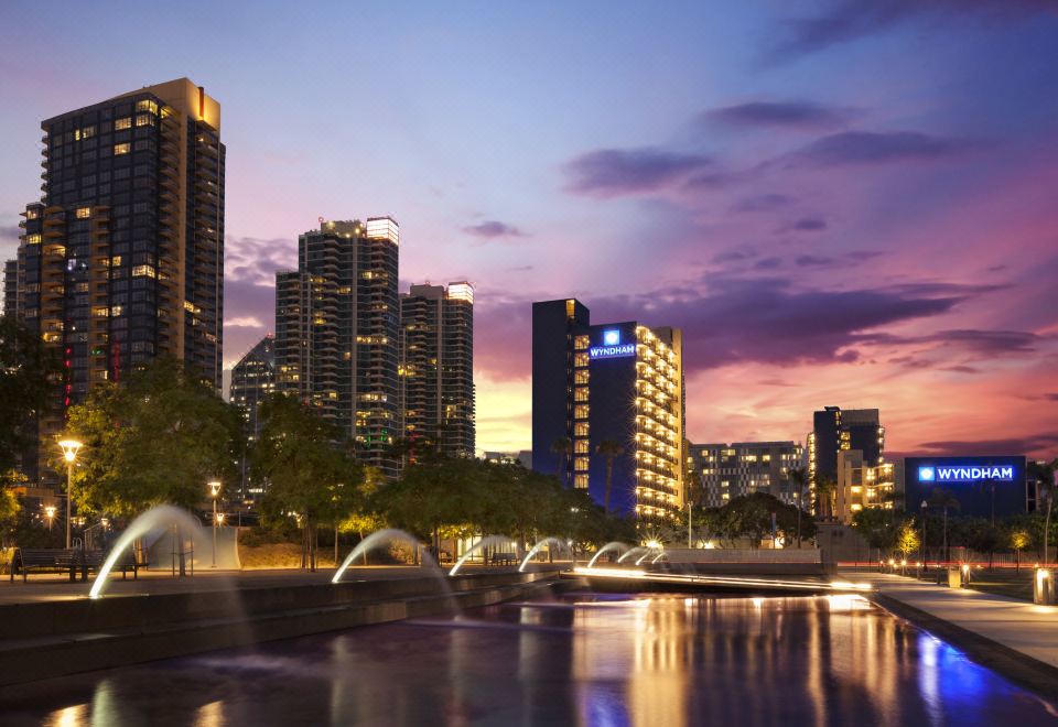 a city skyline at dusk , with tall buildings and a body of water in the foreground at Wyndham San Diego Bayside