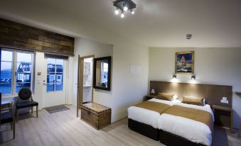 a hotel room with two beds , one on the left and one on the right side of the room at Hlid Fisherman's Village