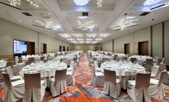 a large banquet hall filled with round tables and chairs , ready for a formal event at Hard Rock Hotel Tenerife