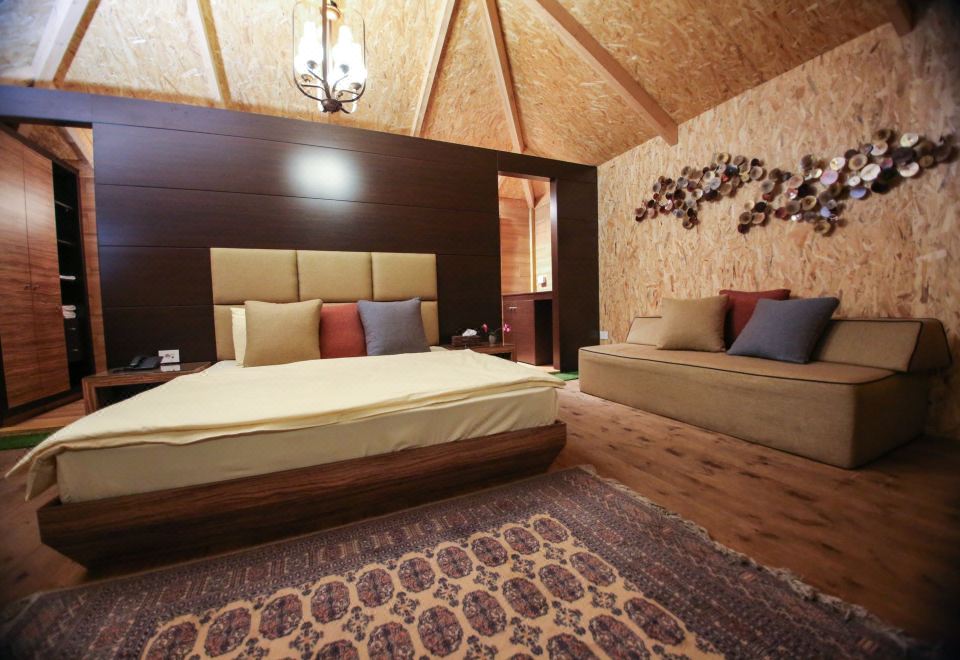 a large bed with a beige comforter is in a room with wooden walls and ceiling at Four Seasons Halat